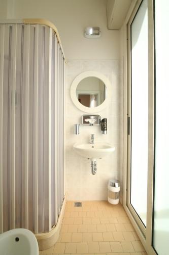 een badkamer met een wastafel en een spiegel bij Hotel Soave in Rimini