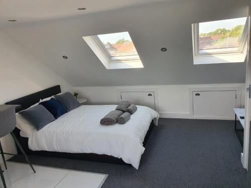 a bedroom with a large bed with two windows at New Self Contained Flat,in Hayes, Free Parking in Northolt