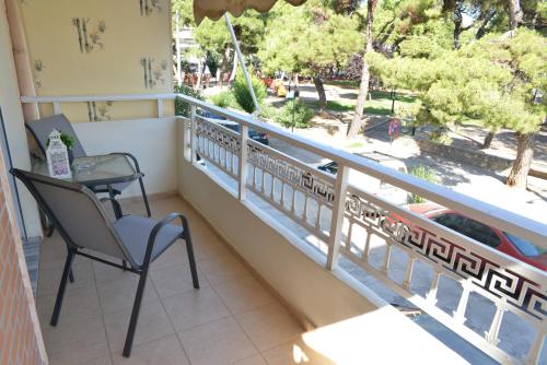 einen Balkon mit einem Stuhl, einem Tisch und Aussicht in der Unterkunft PineParkView Apartment in Alexandroupoli