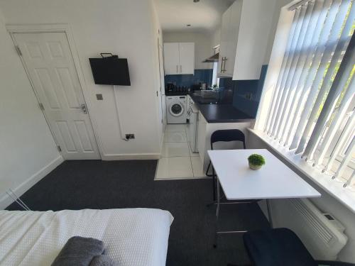a room with a bed and a table and a kitchen at New Self Contained Flat,in Hayes, Free Parking in Northolt
