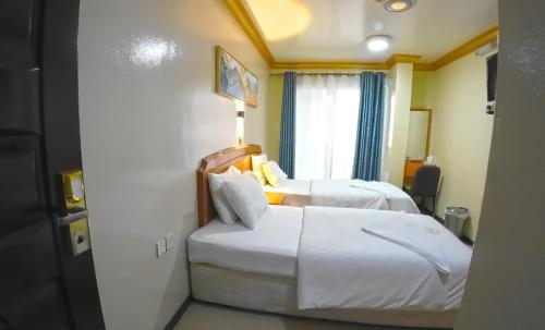 a hotel room with two beds and a window at Maaeen Hotel in Dubai