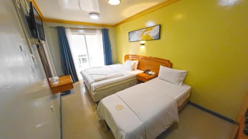 a small room with two beds and a window at Maaeen Hotel in Dubai