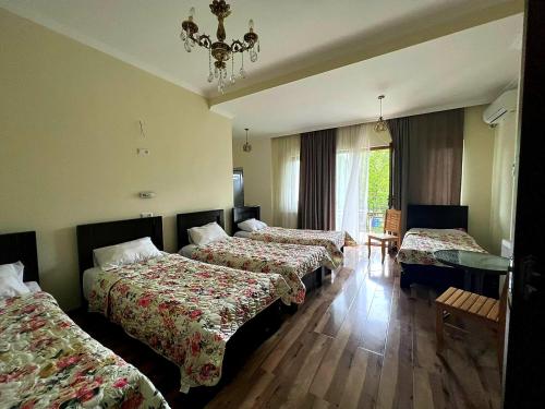 a hotel room with three beds and a chandelier at Four Seasons in Kutaisi in Kutaisi