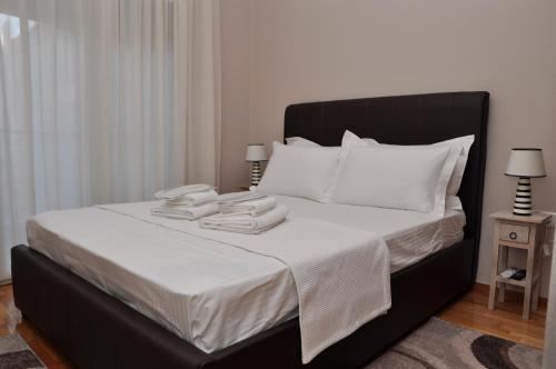 een slaapkamer met een bed met witte lakens en witte kussens bij Friendly Flat 3 in Edessa