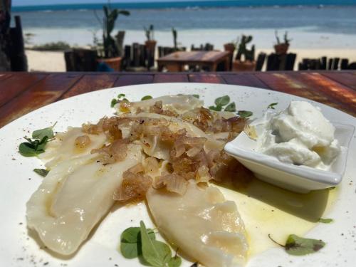 a plate of food on a table near the beach at Secret Beach Bungalows in Haad Son