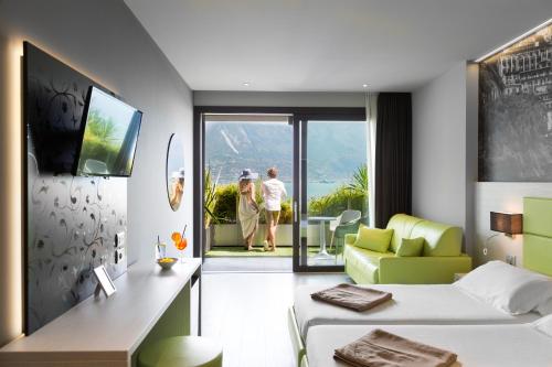 ein Hotelzimmer mit einem Bett und einem Wohnzimmer in der Unterkunft Hotel La Fiorita in Limone sul Garda