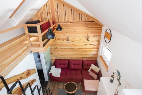 um quarto no sótão com um sofá vermelho e uma escada em Lavender Lodge Bled em Bled