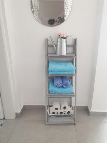 a shelf in a bathroom with towels and a mirror at חצבים על הואדי in Arad