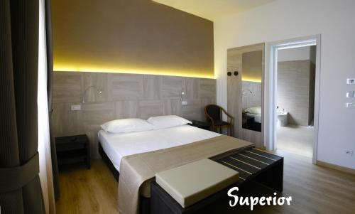 a bedroom with a large bed and a bathroom at Hotel Lory My Wellness SPA in Chianciano Terme