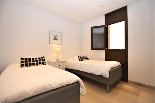 a bedroom with two beds and a television in it at Estepona East Apartment DAISY in Estepona