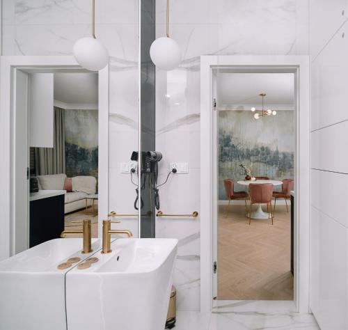 een witte badkamer met een wastafel en een eetkamer bij Apartament Zamojski Rynek in Zamość