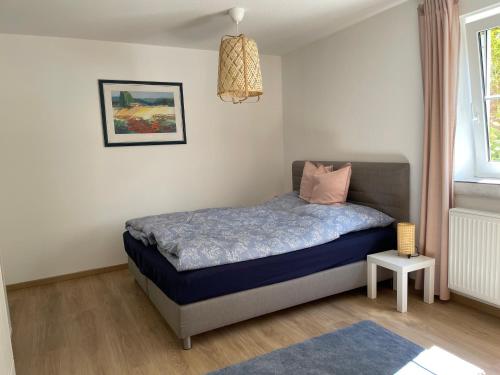 a bedroom with a bed with a pink pillow on it at Schöne Wohnung mit Pool und Sauna zum Wohlfühlen in Oberhausen