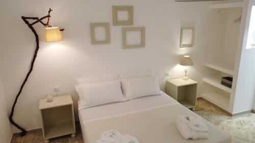 a bedroom with a white bed with two tables and a lamp at Dimora TerraNostra&Spa in Ugento
