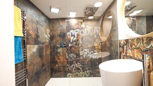 a bathroom with a wall covered in graffiti at Haus8 – dein Genussferienhaus in Mettlach