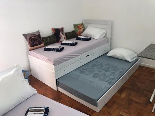 una camera da letto con un grande letto bianco con cuscini sopra di Estúdio 73 a San Paolo