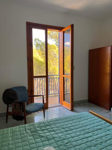 a bedroom with a bed and a door to a balcony at A casa di Ludo in Montecorice