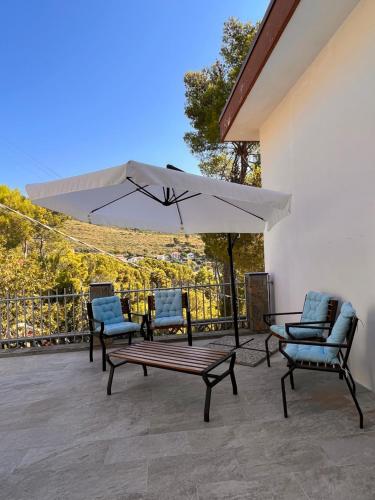 un patio con due sedie, un tavolo e un ombrellone di A casa di Ludo a Montecorice