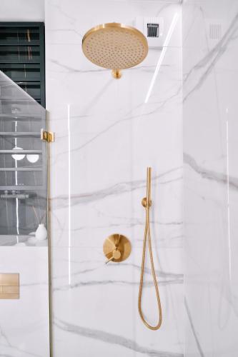 a bathroom with a shower with white marble walls at Apartament Zamojski Rynek in Zamość