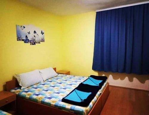 a bedroom with a bed with a blue curtain at Apartments Kalistos in Star Dojran