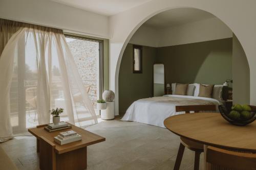 a bedroom with a bed and a table and a window at BATU Luxury Apartments in Preveza