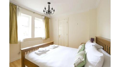 オックスフォードにあるPass the Keys Central Oxford 2 Bed Apartment with Parkingの白いシーツと窓のあるベッドのある寝室