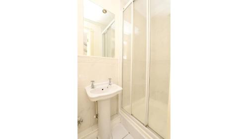 a white bathroom with a sink and a shower at Pass the Keys Central Oxford 2 Bed Apartment with Parking in Oxford