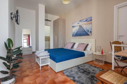 una camera da letto con letto con lenzuola blu e cuscini rosa di B&B vera's home pompei a Pompei