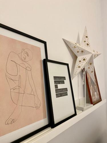 a shelf with two framed pictures and a star at Velvet Studio in Târgu-Mureş