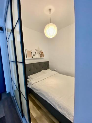 małą sypialnię z łóżkiem i lustrem w obiekcie Velvet Studio w mieście Târgu Mureş