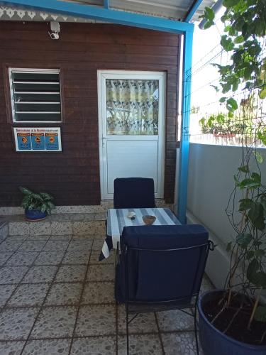 a patio with a table and chairs in front of a door at Le Tuléar - Résidence Gandhi in Saint-Pierre