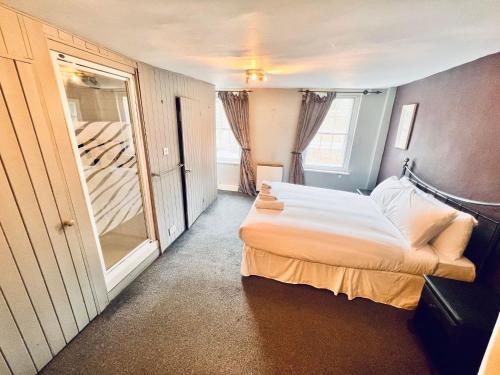 a small bedroom with a bed and a mirror at George & Dragon Hotel in Buckinghamshire