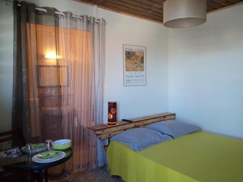 um quarto com uma cama verde e uma mesa com uma mesa em Le Tuléar - Résidence Gandhi em Saint-Pierre