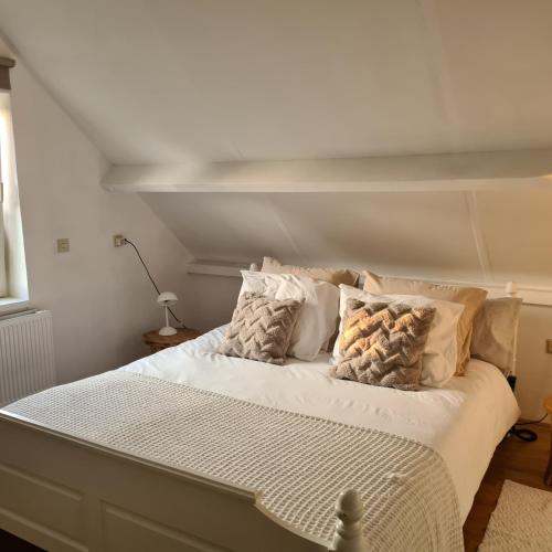 a white bed with pillows on it in a room at Maisonnette Slijkplaat 18 in Hoofdplaat