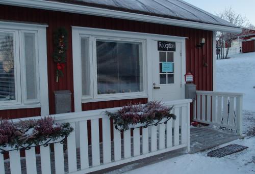 a house with a white fence in the snow at Lomamaja Pekonen Apartments in Muonio