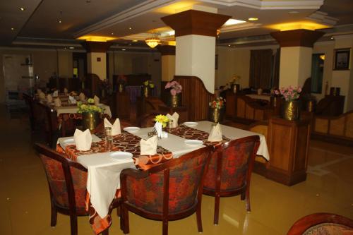 a dining room with tables and chairs in a restaurant at hotel bessota international in Thiruvalla