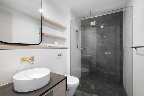 a bathroom with a toilet and a sink and a shower at Sea view Beachfront apartment in surfers in Gold Coast