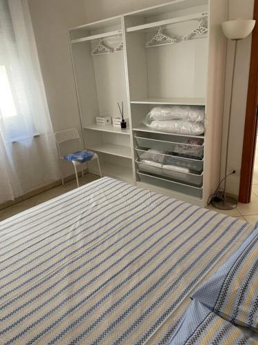 ein Schlafzimmer mit einem Bett und einem blauen Stuhl in der Unterkunft Corso Umberto Apartment in Soverato Marina