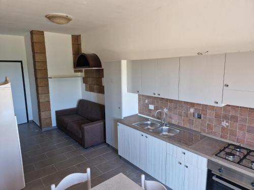 a kitchen with a sink and a couch in a room at Nina's house 2 a 300 metri dal mare in Santa Caterina Dello Ionio Marina