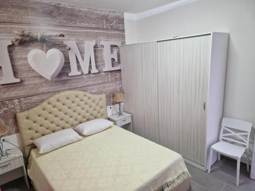 ein Schlafzimmer mit einem Bett und einer Wand mit einem Herzschild in der Unterkunft Nina's house 2, a 300 metri dal mare in Santa Caterina Dello Ionio Marina