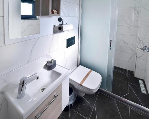 a white bathroom with a sink and a toilet at Nibras Villa Resort Hotel in Sapanca