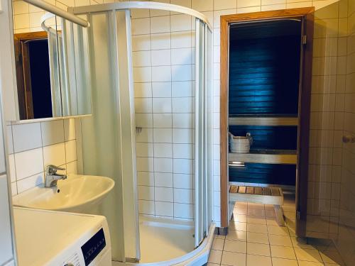uma casa de banho com um lavatório e um chuveiro em Tallinn Seaside Apartment em Taline