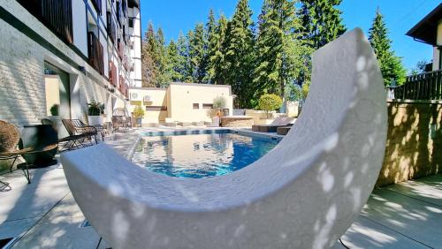 a swimming pool with a ramp leading to a building at Elexus Predeal in Predeal