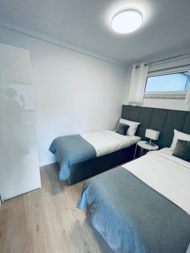 um quarto de hotel com duas camas e uma janela em Beds Friends Apartments em Zator