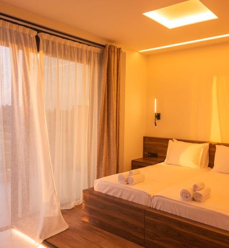 a bedroom with a bed with two towels on it at Salt Boutique Hotel in Palouki