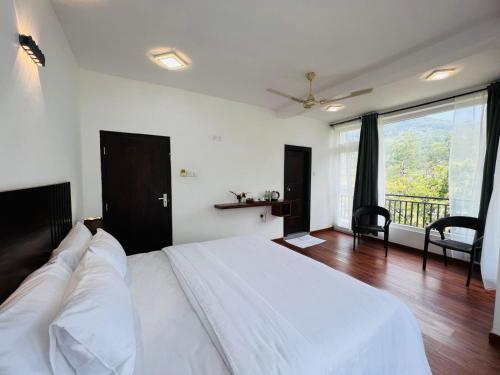 a bedroom with a white bed and a large window at Dream Stay Green in Nuwara Eliya