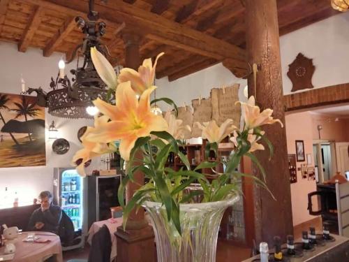 a vase filled with yellow flowers on a table at Hotel Due Colonne in San Bonifacio