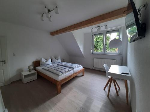 a bedroom with a bed and a desk and a window at Das Vogelhaus in Hemfurth-Edersee