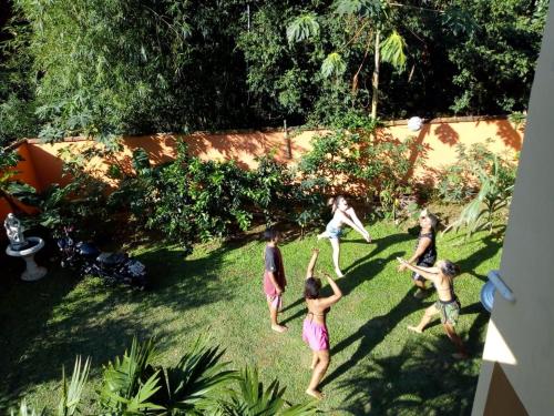 a group of people playing with a frisbee in a yard at Pousada do Bote - Apart Suítes em " Sítio Santa Helena" , próximo ao Sana in Casimiro de Abreu