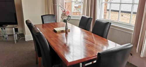 a wooden table with chairs and a vase with flowers on it at Westmount 1st North Apt in Scarborough