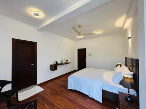 a bedroom with a white bed and a ceiling fan at Dream Stay Green in Nuwara Eliya